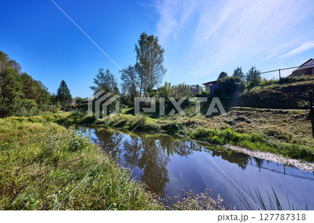 Serene Riverbank Scene with Lush Greenery 127787318