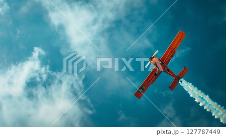 An airplane wows spectators with stunning aerial maneuvers, showcasing the pilot's skill and control. 127787449
