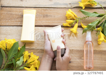 hand of girl holding sunscreen spf50, water spray for health care skin face with body lotion hand of girl holding sunscreen spf50, water spray for health care skin face with body lotion 127787491
