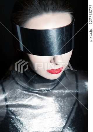 Abstract woman studio portrait with make-up and metallic eyeglasses or helmet covering her eyes 127788777