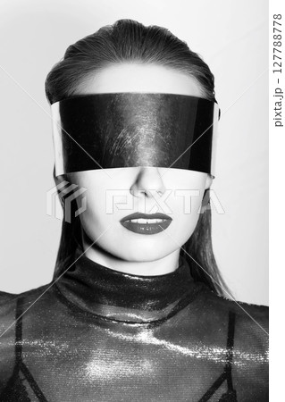 Abstract woman studio portrait with make-up and metallic eyeglasses or helmet covering her eyes Abstract woman studio portrait with make-up and metallic eyeglasses or helmet covering her eyes 127788778