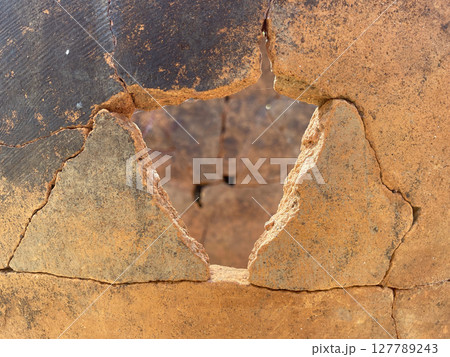 Antique clay vase with cracks. Old terracotta jug close-up, ancient background. 127789243