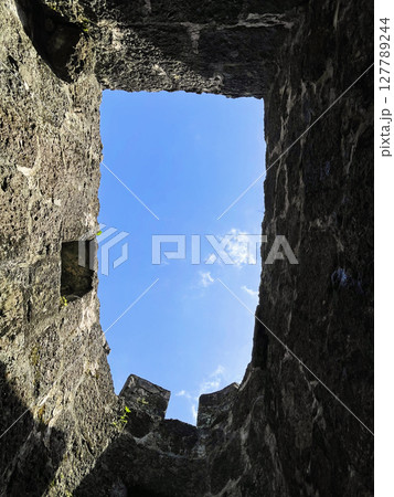 Empty stone window border with blue sky and white clouds 127789244