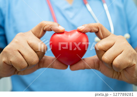 Asian woman doctor holding red heart for health in hospital. 127789281