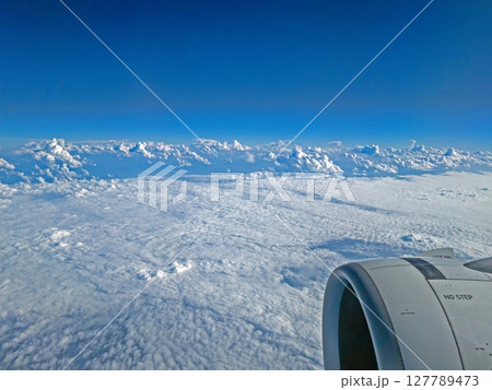 View over clouds from airplane with engine visible 127789473