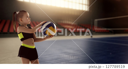 Young girl holding volleyball preparing to serve in lit indoor sports arena. Youth athleticism 127789519