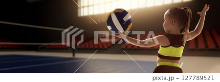 Young girl preparing to serve volleyball on indoor court. Childhood ambitions 127789521