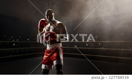 Boxer preparing to strike in the center of the 3D ring. Boxing event campaigns 127789539