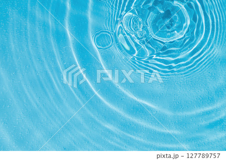 drops on water with circles on a blue background 127789757