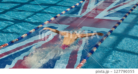 Competitive swimmer in UK flag lane mid-butterfly stroke. National sports identity 127790355