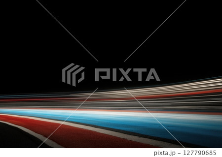 dynamic streaks of red, white, and blue light trails against a black backdrop 127790685