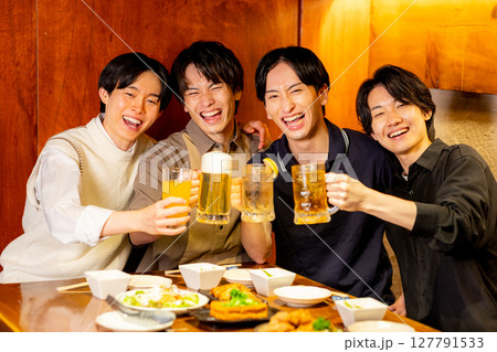 居酒屋で乾杯する若い男子 127791533