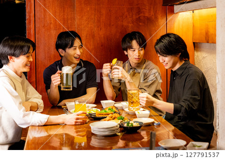 居酒屋で乾杯する若い男子 127791537