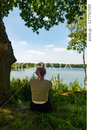 A Child and an Adult Enjoying Nature Together by the Beautiful Lake and Surroundings 127792509