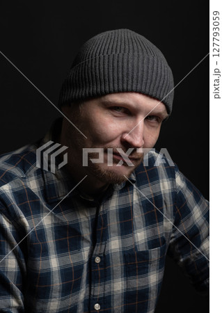 Man with winter hat and checkered shirt studio portrait 127793059