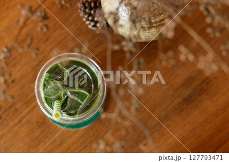 Scoop of Matcha green tea ice cream with bun bread on wooden table. 127793471