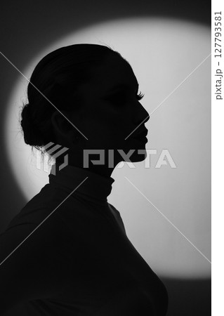 Woman profile black silhouette portrait in bright illuminated round light background 127793581