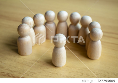 Beige Wooden Figures In Semi Circle Facing Center On Wooden Table 127793609