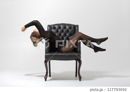 Beautiful woman with tight black clothes lying on chair portrait Beautiful woman with tight black clothes lying on chair portrait 127793692
