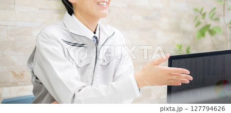 作業着で建築や施工などのパソコンの統計資料を説明する若い男性ビジネスマン　施工管理や説明など 127794626