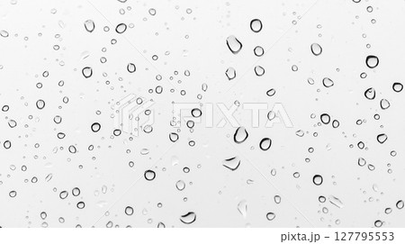 Raindrops form elegant droplets on a transparent glass pane, macro photo 127795553