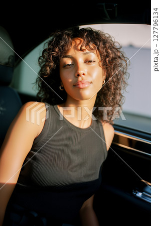 A woman with curly hair is sitting in a car 127796134