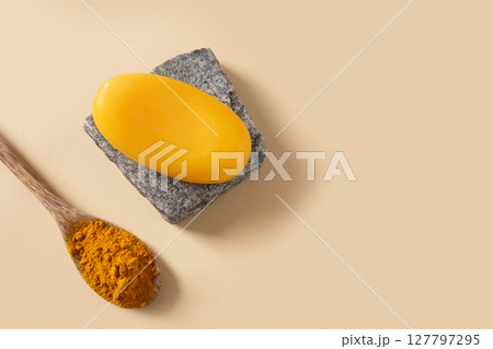 Handmade turmeric soap on stone. Organic skincare product perfect for wellness, beauty, and organic body care concepts. View from above. Handmade turmeric soap on stone. Organic skincare product perfect for wellness, beauty, and organic body care concepts. View from above. 127797295