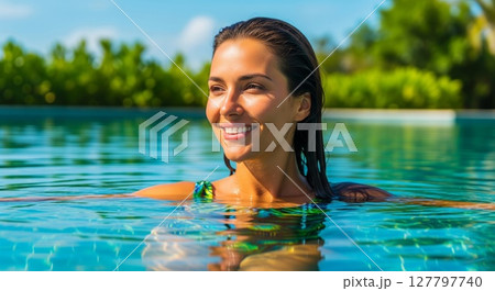 Radiant Woman Enjoying Crystal Clear Turquoise Swimming Pool on Sunny Tropical Day 127797740