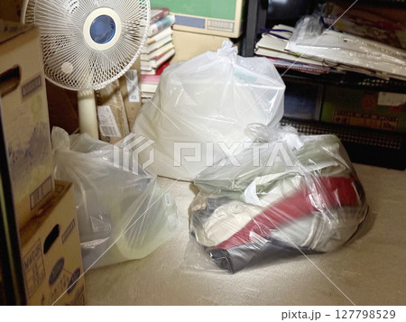 暗い部屋で光が当たる扇風機やゴミ袋 127798529