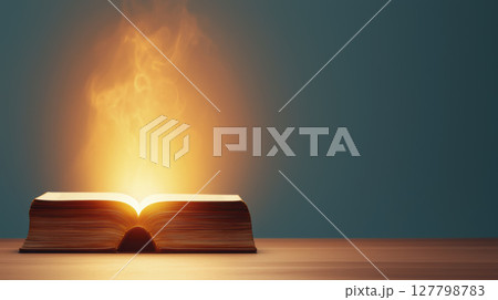 Glowing book with golden light rising from its pages symbolizing knowledge and inspiration 127798783