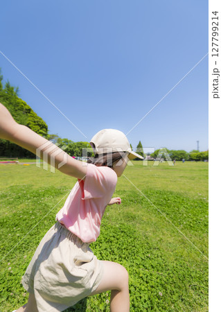 公園の芝生を元気に駆ける女の子の後ろ姿 公園の芝生を元気に駆ける女の子の後ろ姿 127799214