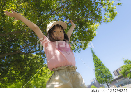 両手を広げて青空の下ではしゃぐ女の子 両手を広げて青空の下ではしゃぐ女の子 127799231