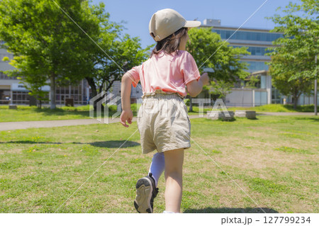 公園の芝生を元気に駆ける女の子の後ろ姿 公園の芝生を元気に駆ける女の子の後ろ姿 127799234