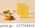 Turmeric soap bars with raw turmeric roots and wooden spoon with turmeric powder. Natural and organic ingredients for skincare. Close up. 127799838
