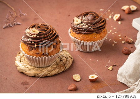 Chocolate chip muffins decorated with chocolate ganache and hazelnut Chocolate chip muffins decorated with chocolate ganache and hazelnut 127799919