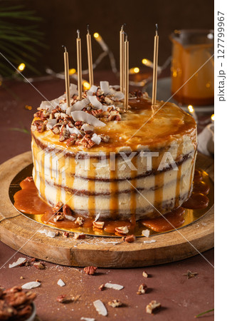 Delicious caramel cake with pecan nuts and coconut flakes 127799967