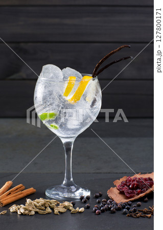 Gin tonic cocktail with ice vanilla lima and varied spices Gin tonic cocktail with ice vanilla lima and varied spices 127800171