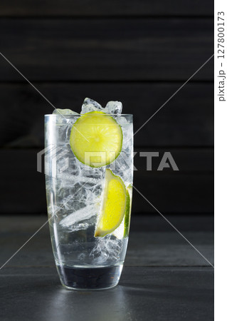 Gin tonic cocktail with lima and ice cube on black Gin tonic cocktail with lima and ice cube on black 127800173