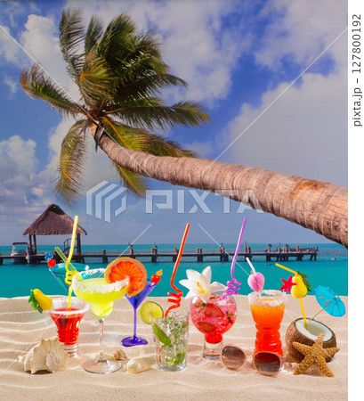 Colorful tropical cocktails at beach on white sand 127800192