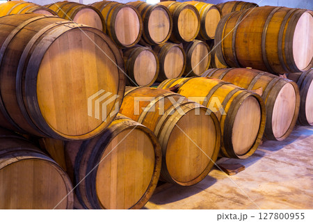 wine wooden oak barrels stacked in a row at winery 127800955