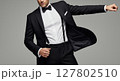 Elegant Man in Black Tuxedo and Suspenders Striking a Bold Pose 127802510