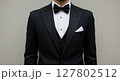 Close-Up of Man Wearing Elegant Black Tuxedo and Bow Tie with White Pocket Square 127802512