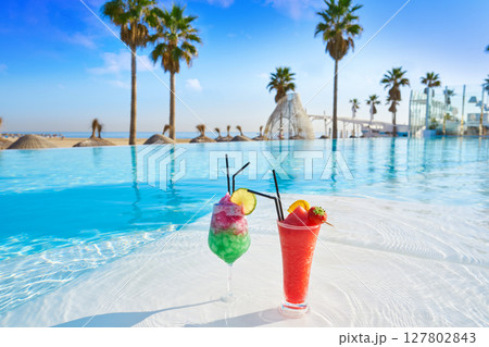 Tropical cocktails in resort infinity pool 127802843
