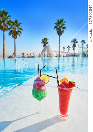 Tropical cocktails in resort infinity pool 127802844