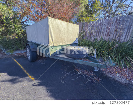 An old rusty trailer stored in a small community carpark An old rusty trailer stored in a small community carpark 127803477
