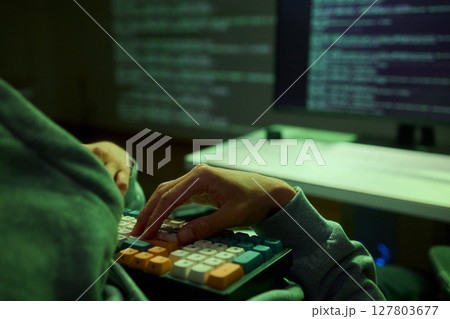 Cybersecurity Analyst Engaged in Writing Code Within a Dimly Lit Environment for Efficiency Cybersecurity Analyst Engaged in Writing Code Within a Dimly Lit Environment for Efficiency 127803677