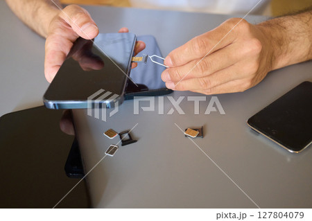 Detailed Process of Installing a SIM Card Utilizing Various Smartphone Components and Accessories 127804079