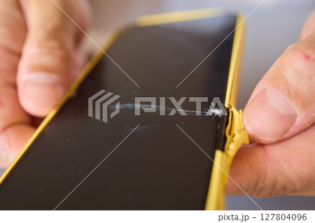 The detailed process for repairing a damaged smartphone screen includes various steps and tools 127804096