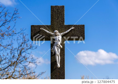 Beautiful Jesus Christ on crucifix, spring Easter budding tree flowers in background, cemetery on a sunny day, new life and religion concept Beautiful Jesus Christ on crucifix, spring Easter budding tree flowers in background, cemetery on a sunny day, new life and religion concept 127804475