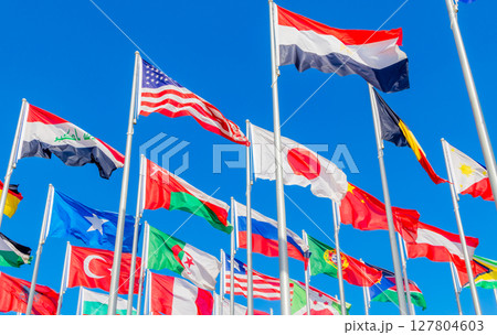 World summit countries national flags waving together on the wind, with American, Japanese, Omani, Chinese, Russian, Iraqi, Egyptian, Somalian, Turkey, Algerian banners waving in the foreground, Doha World summit countries national flags waving together on the wind, with American, Japanese, Omani, Chinese, Russian, Iraqi, Egyptian, Somalian, Turkey, Algerian banners waving in the foreground, Doha 127804603